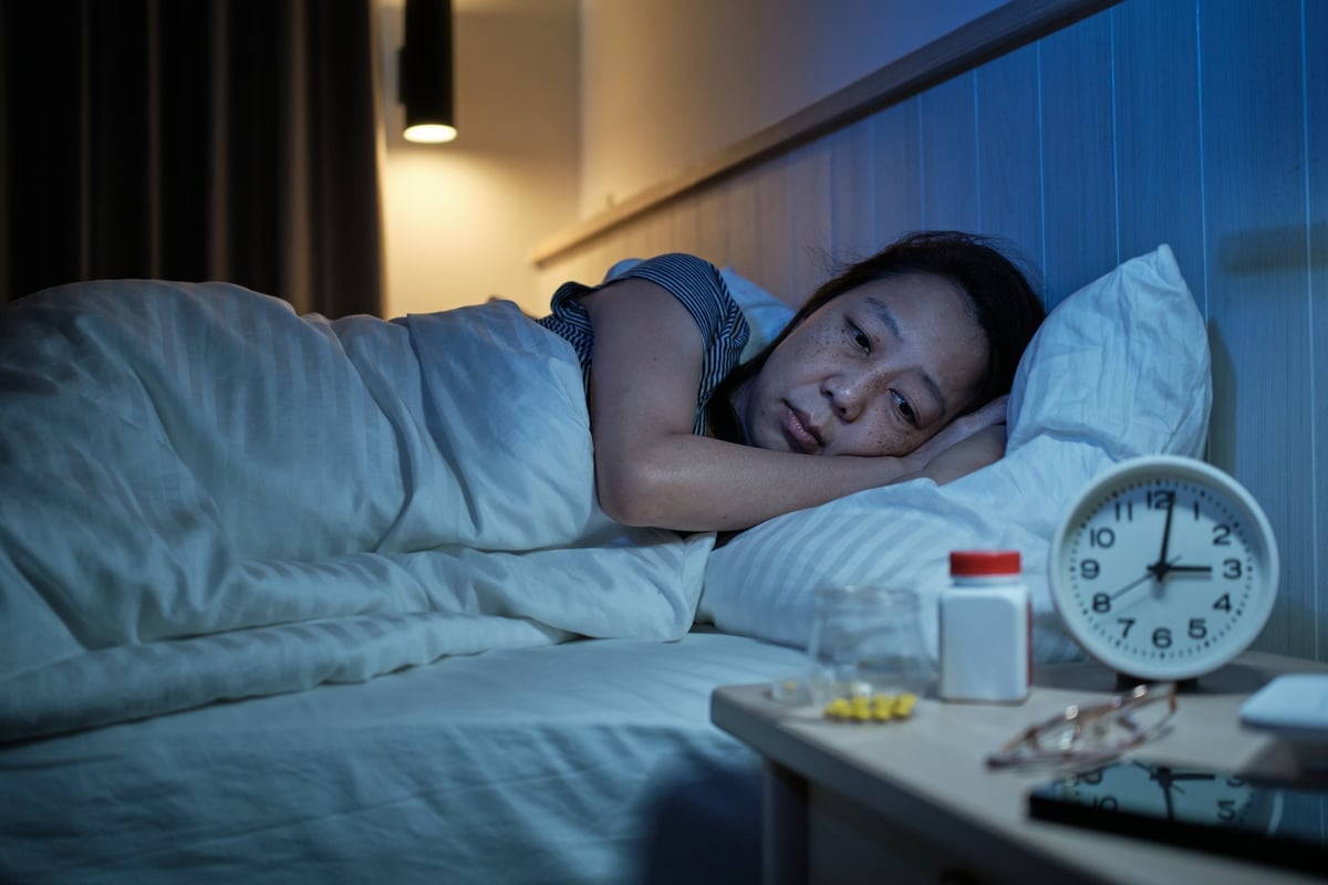 A person lying awake at night, unable to sleep